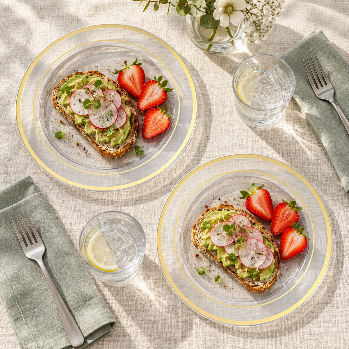 Two identical 10-inch clear gold-trimmed plastic plates with avocado toast and strawberries at a brunch table. Food and styling props not included.