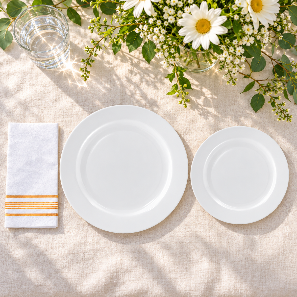 White dinner and dessert plates with gold-striped napkins, overhead two sizes. Food and styling props not included.