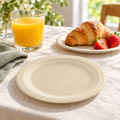 Empty natural beige round dessert plate on cream linen, with croissant, strawberries and orange juice in a bright brunch setting. Representative arrangement; food and styling props not included.