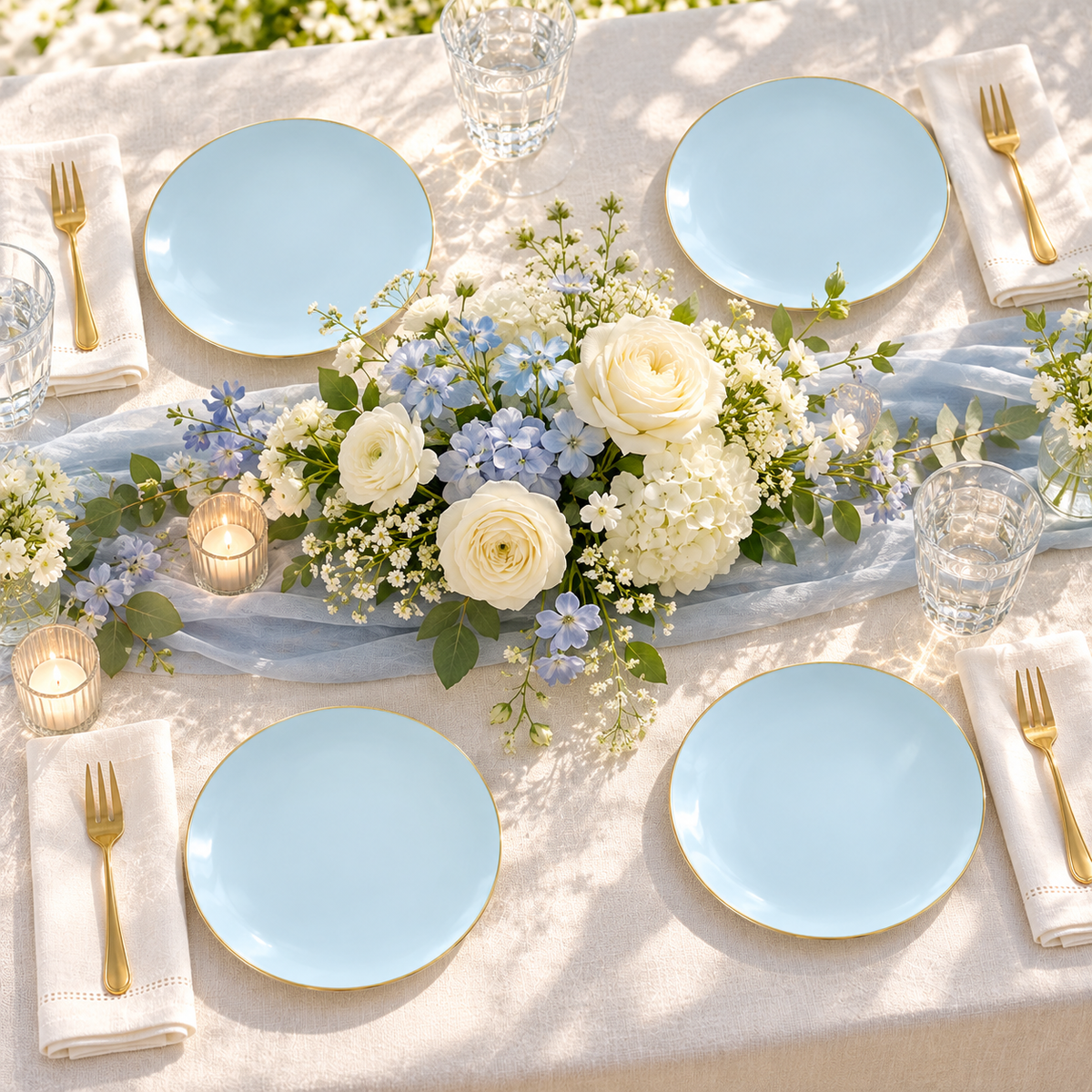 Four pale blue gold edged dessert plates around a white and pale blue floral centerpiece on an ivory linen table. Representative arrangement; food and styling props not included.