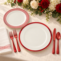 Red and off white plastic place setting on cream linen beside red and cream flowers Representative arrangement; food and styling props not included.