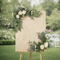 White rose floral swags on a wooden wedding welcome sign