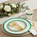 Ivory disposable plastic Christmas plates with green patterned trim, gold flatware and cup styled in a festive place setting