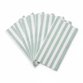 Fanned stack of sage green and white striped paper guest napkins on white