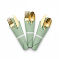 Pre-rolled gold plastic cutlery wrapped in sage green napkins fanned on white