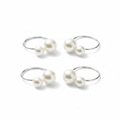 Set of silver pearl napkin rings, each with two white pearls, on a white background