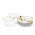 Stacked clear plastic party plates with ornate gold filigree rim on white