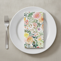 Watercolor rose paper guest napkin folded on a plain white plate place setting