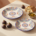 Colorful Mediterranean Talavera ceramic plate set with figs, olives and bread on cream linen