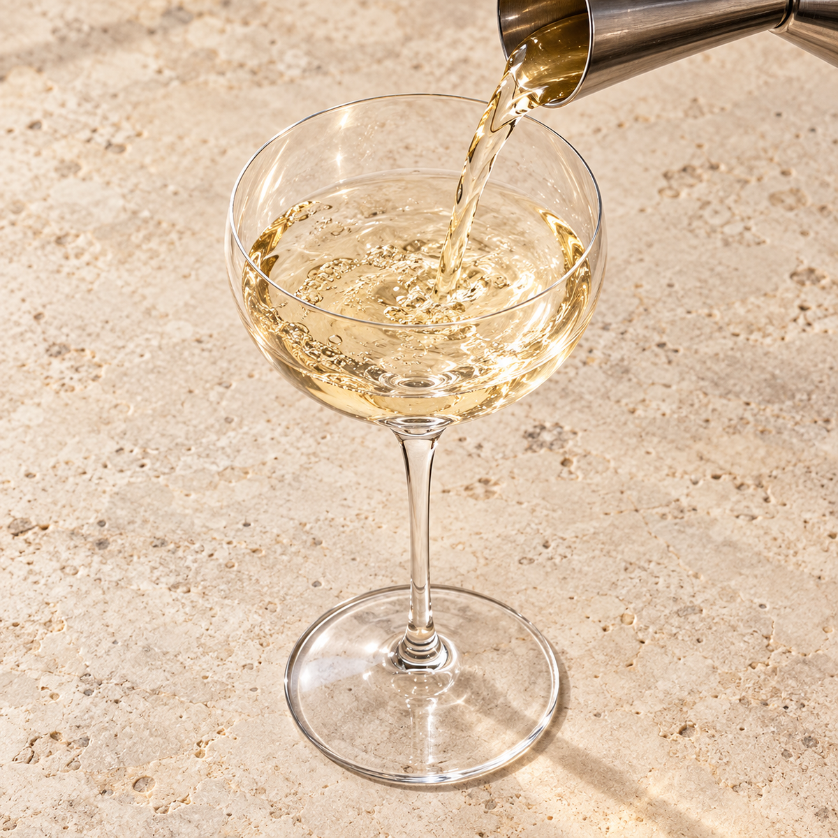 Coppa crystal glass cocktail pour from an elevated angle