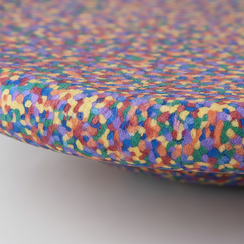 Close-up of the colorful speckled recycled-foam deck texture of the balance board