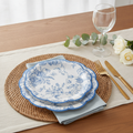 Blue chinoiserie floral disposable paper dessert plates styled on a woven placemat with gold flatware