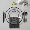 Clear black-rim plastic place setting flat-lay — clear black-rim plates, black cutlery, black napkin and clear black-rim tumbler