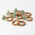 Set of eucalyptus wood-bead jute napkin rings on a white background