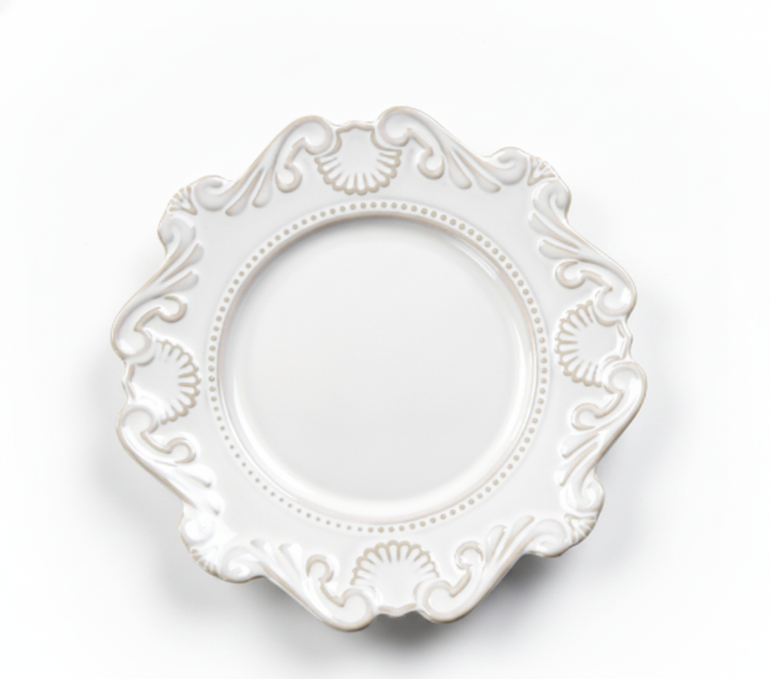 Ornate white baroque porcelain plate with scalloped relief rim on white background