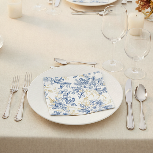 Blue and gold floral paper napkin folded on a white plate place setting