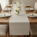 Cream burlap runner styled down an elegant dining table with white florals and gold cutlery