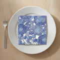 Scandinavian floral paper napkin folded on a plain white plate place setting