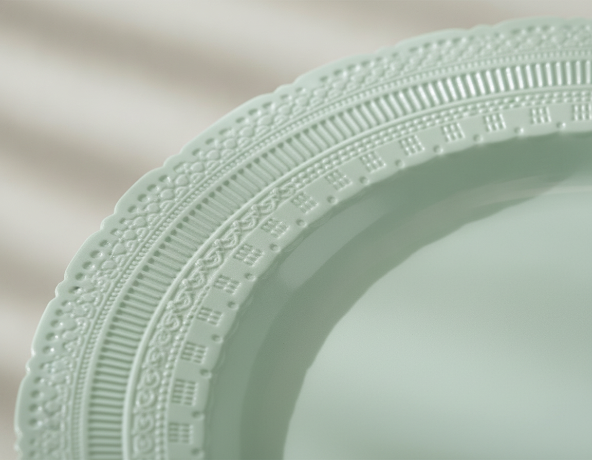 Macro close-up of vintage embossed scalloped rim on a mint-green plastic plate