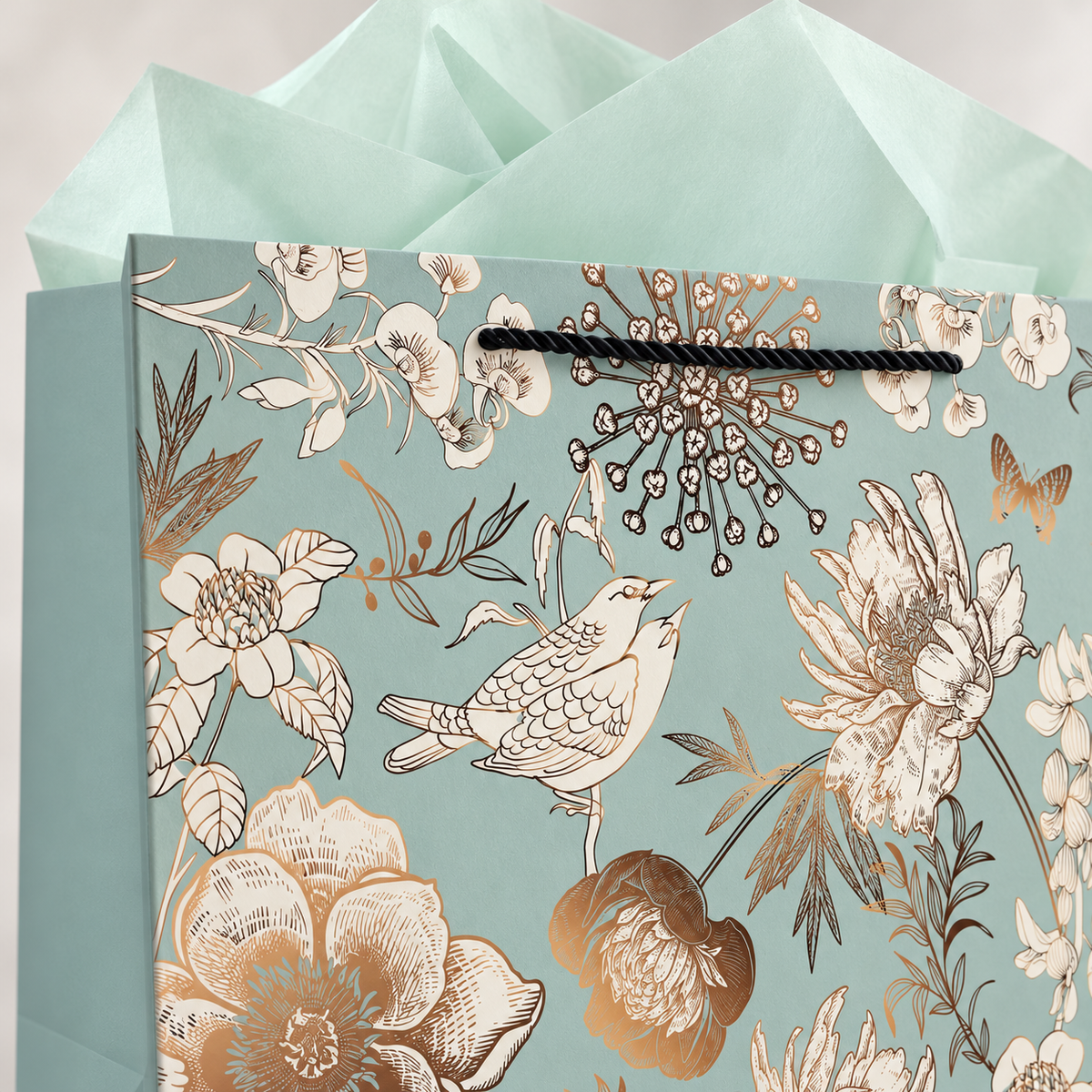 Green floral and bird gift bag with black cord handle and mint tissue – floral detail
