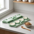 Dumpling press with wrappers laid in the molds and a bowl of filling
