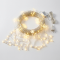 Warm white LED string lights with star and Christmas-shaped charms coiled packshot on white background