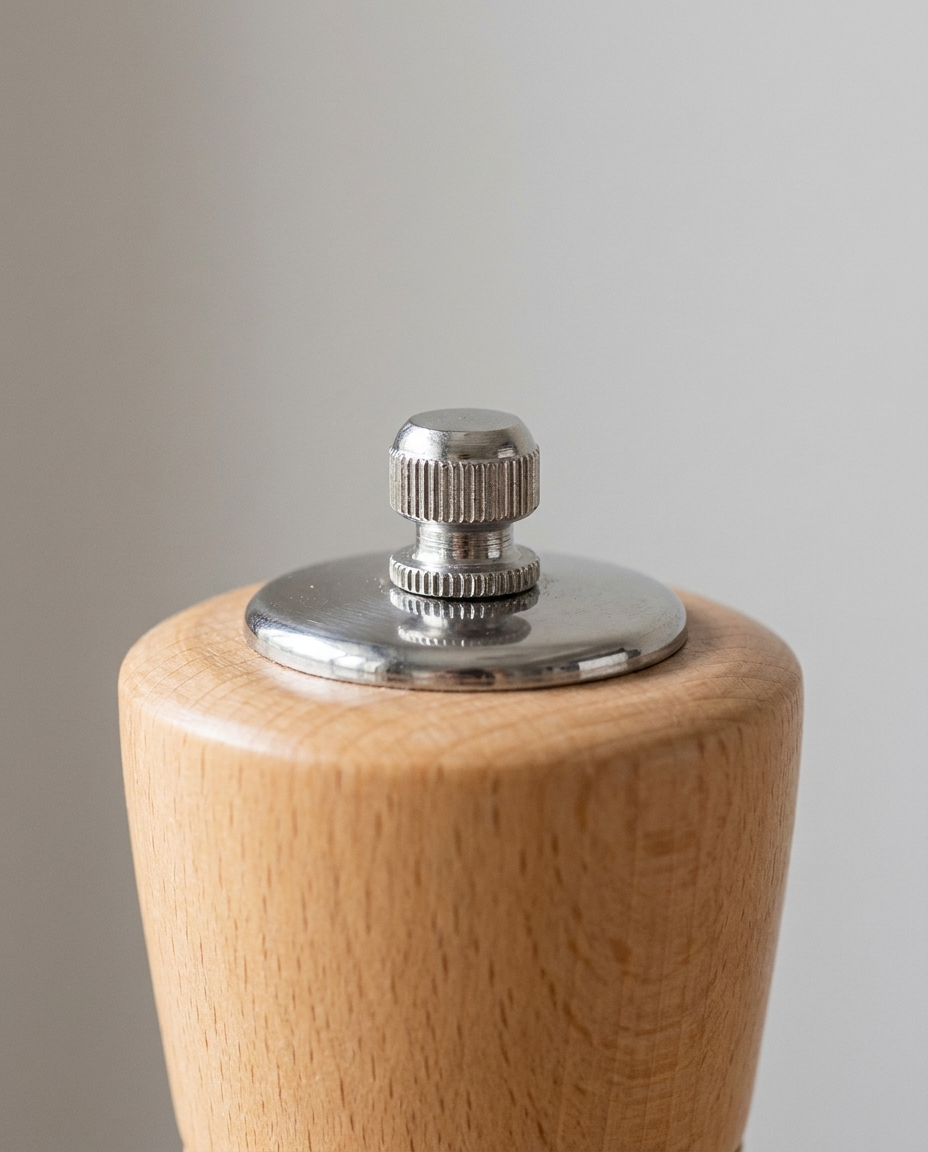 Close-up of the stainless steel grinder mechanism and adjustment knob