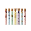 Set of 7 botanical bath salt glass tubes on pure white background