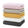 Stack of cotton waffle towels in soft colors on pure white background product photo