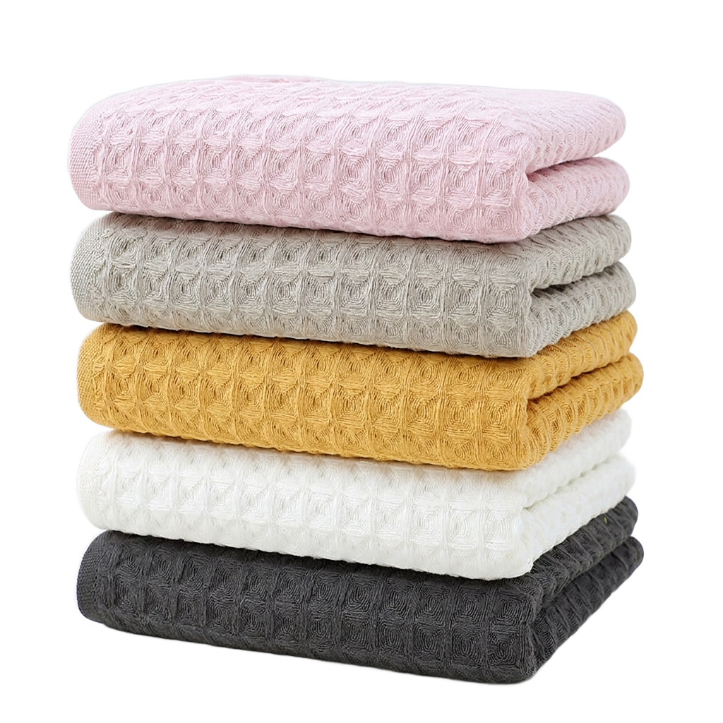 Stack of cotton waffle towels in soft colors on pure white background product photo