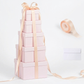 Pink nesting gift box tower with blush ribbon, ribbon roll and card