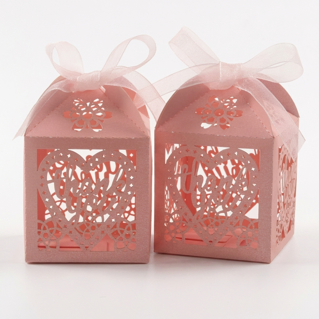 Pink laser-cut heart favor boxes with ribbons