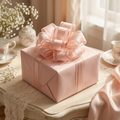 Blush pink pull bow on a wrapped wedding gift box