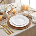 Elegant white dinnerware place setting with gold cutlery and woven placemat