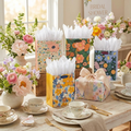 Floral gift bags styled on a bridal shower table with fresh flowers