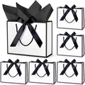 White gift bag with black trim, rope handles, and black satin bow