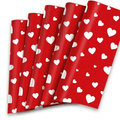 Red wrapping paper with white hearts, flat sheets fanned out