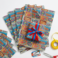 Superhero comic printed tissue paper gift wrap flat-lay with wrapped gift box and ribbon