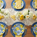 Lemon and blue tile summer party plates tablescape with yellow napkins and fresh lemon slice garnishes