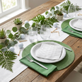 Golf-themed party table setting with disposable plates napkins and forks on green linen