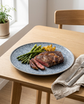 Nordic blue ceramic steak plate with ribeye and asparagus on Scandinavian dining table