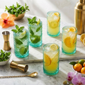 Six aqua blue hobnail vintage glasses with mojito and lemonade cocktails on marble bar
