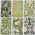 All six William Morris floral tea towels overhead flat-lay on marble showing each ornate botanical pattern
