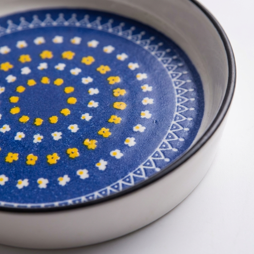 Close-up of yellow blue orange medallion glaze pattern on ceramic disc plate