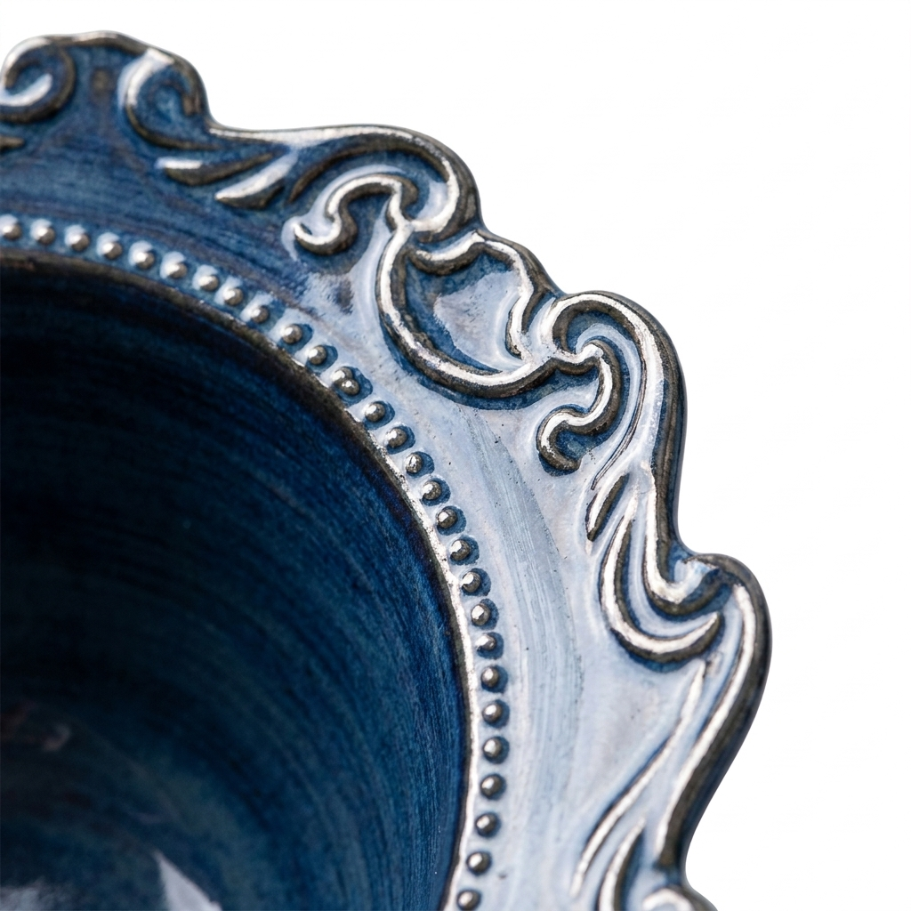 Close-up of baroque porcelain plate ornate scalloped rim and rich blue-silver color glaze detail