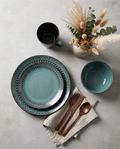 Vintage teal stoneware dining collection — plates, bowls and mugs styled as a complete place setting on concrete surface
