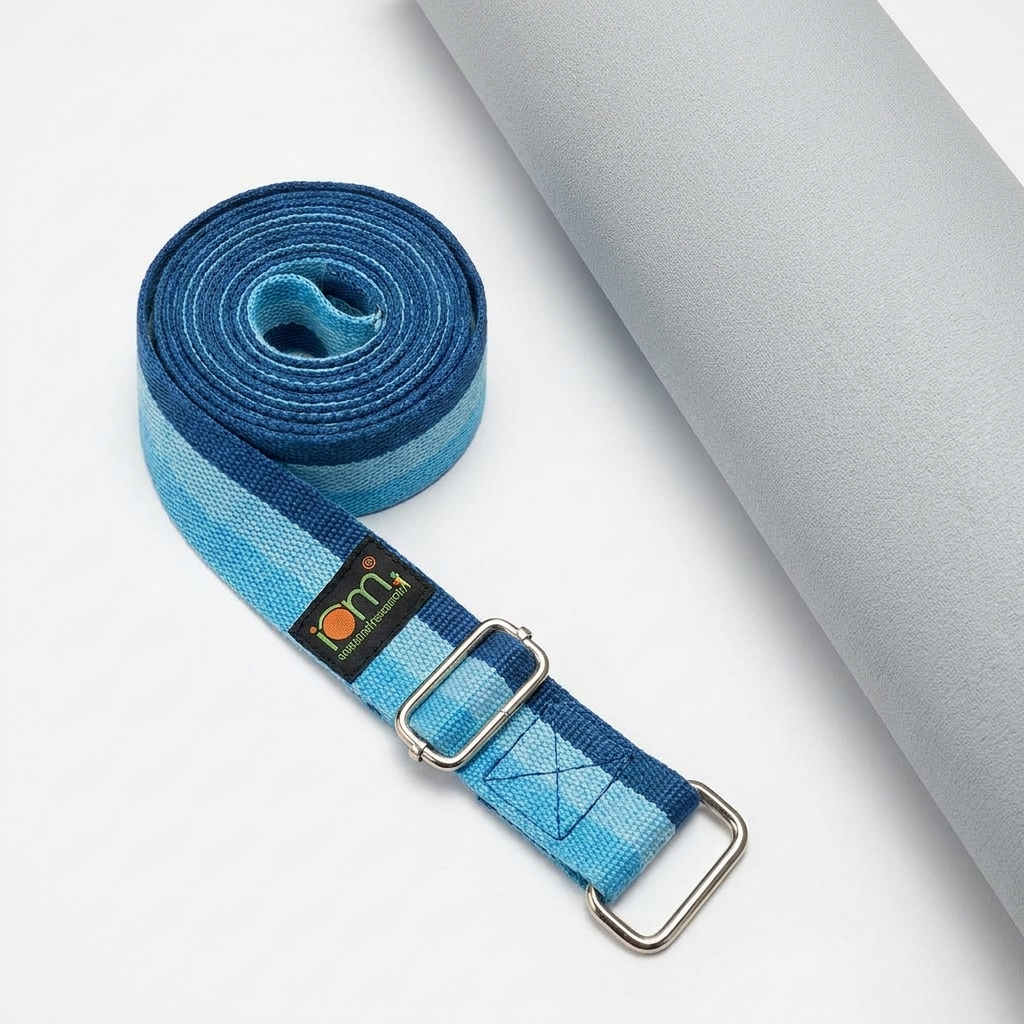Blue yoga strap flat-lay on white surface next to rolled yoga mat showing scale and buckle hardware