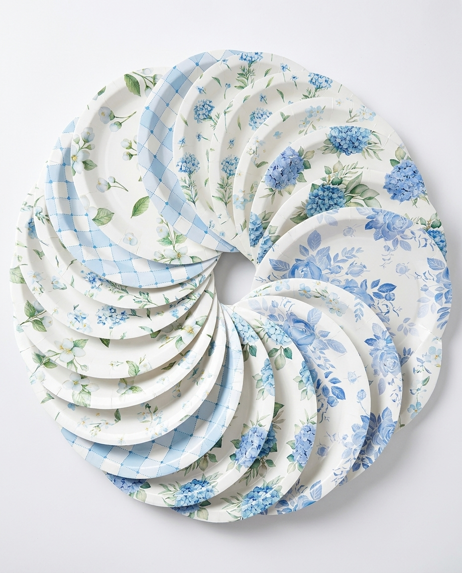 Overhead flat-lay of all 60 blue and white floral paper plates displaying 10 unique vintage designs in a fan arrangement