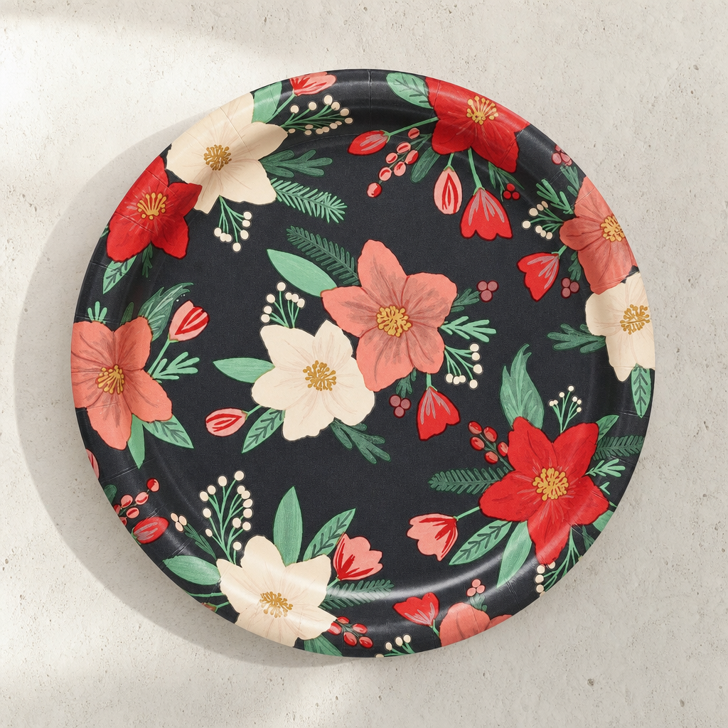 A single round paper dessert plate face-up, charcoal ground painted with red, coral and ivory winter blooms and sage foliage