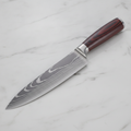 Damascus chef knife with red-brown pakkawood handle on marble